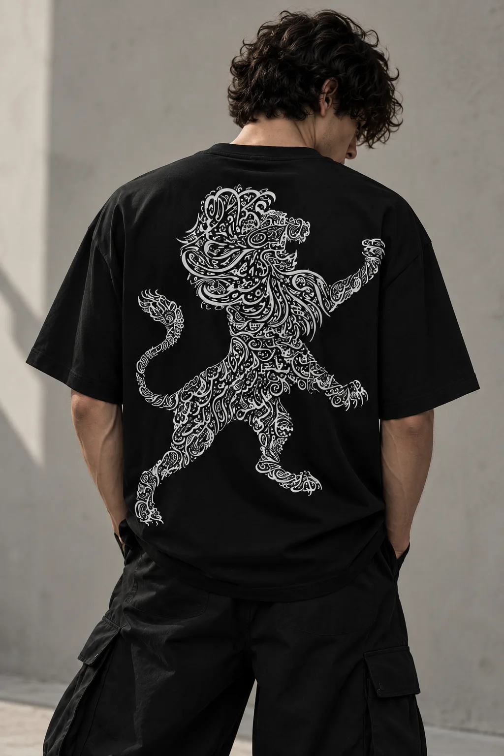 Black and white oversized T-shirts featuring a lion shaped from intricate Arabic calligraphy, blending cultural expression with modern streetwear.