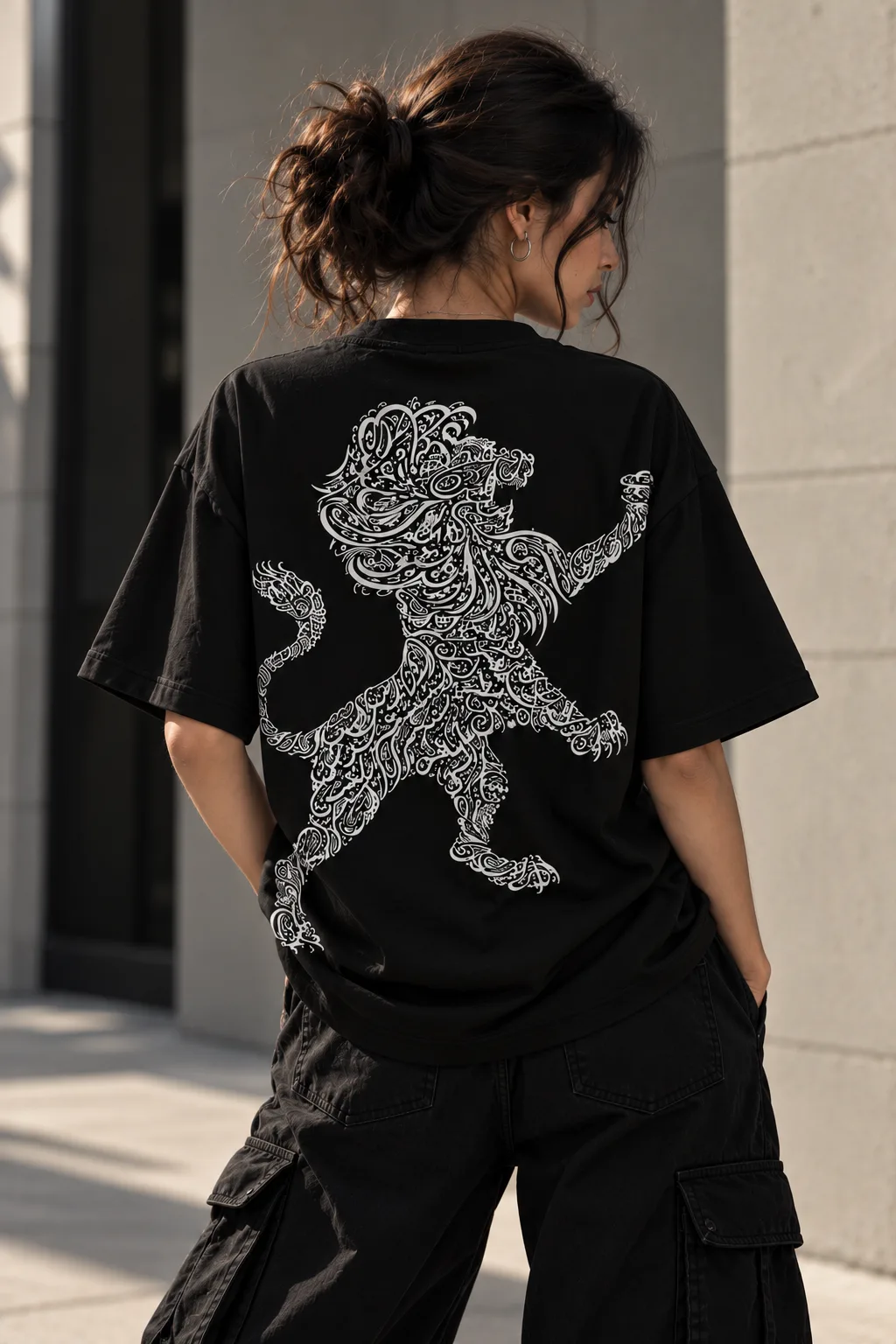 Black and white oversized T-shirts featuring a lion shaped from intricate Arabic calligraphy, blending cultural expression with modern streetwear.