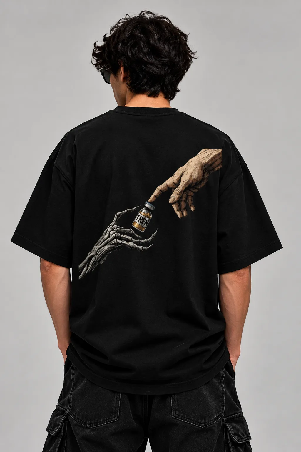 Oversized black and white streetwear T-shirts featuring a human hand reaching toward a skeletal hand holding a vial labeled “TREN,” printed across the back.