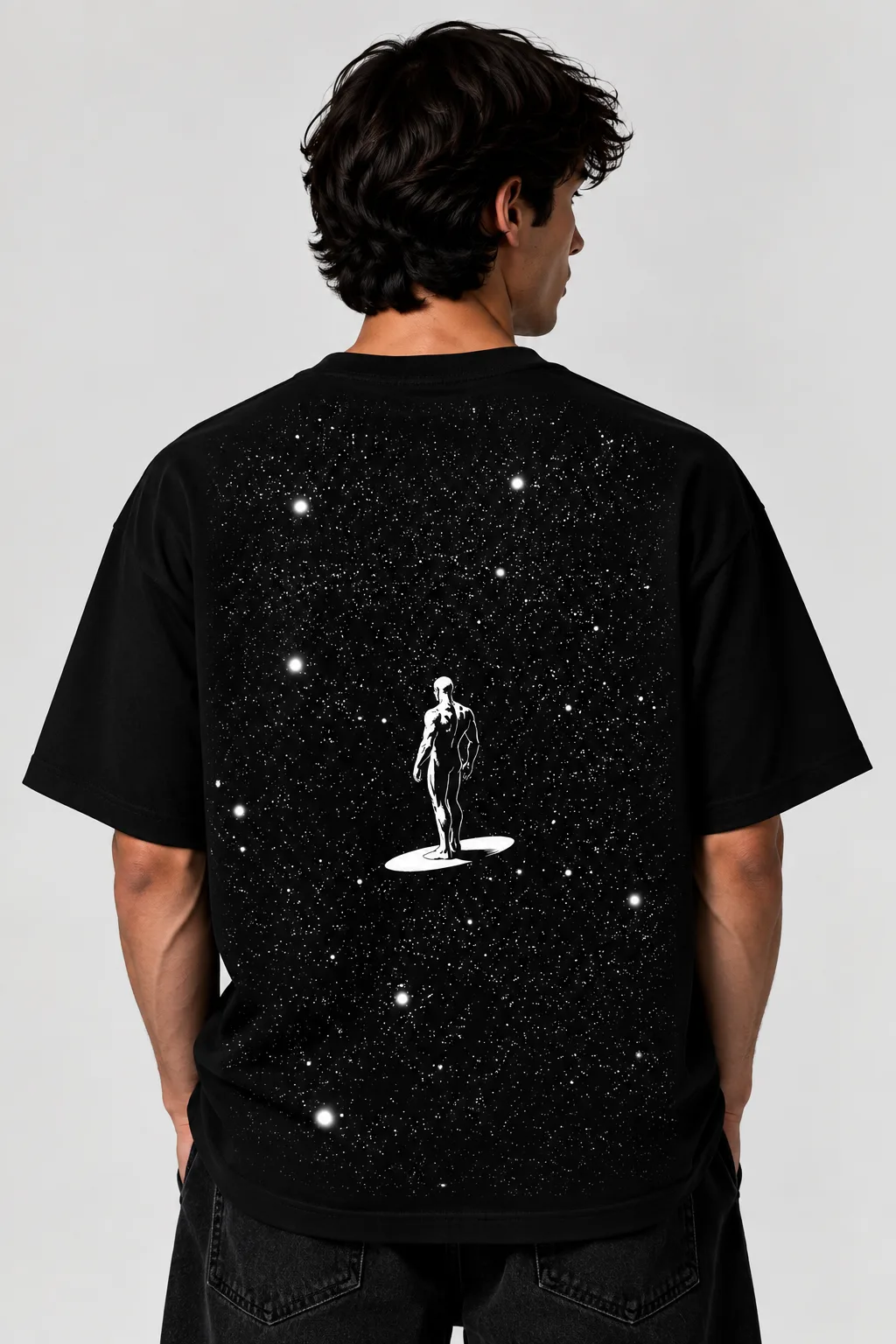 Black oversized T-shirt worn by a male model, featuring a white starfield design with a human figure on the back.